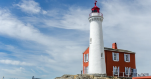 Red and white lighthouse on a bright day.