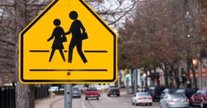 Close up of yellow school crossing sign.