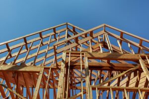 Upward view of wood, roof framing on house being built.