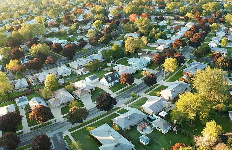 Aerial view of residential houses in suburb on a sunny autumn morning.