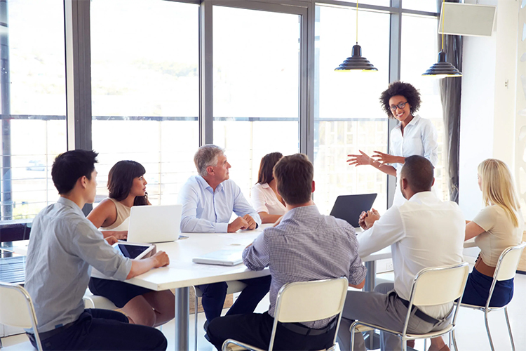 Group meeting around a large table in an office setting.