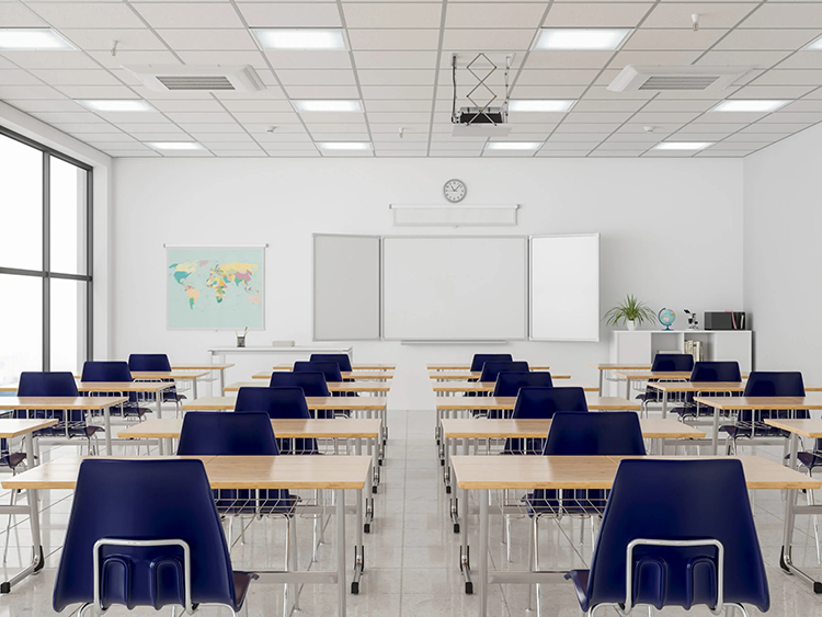 Empty white class room with many desks and blue plastic chairs.