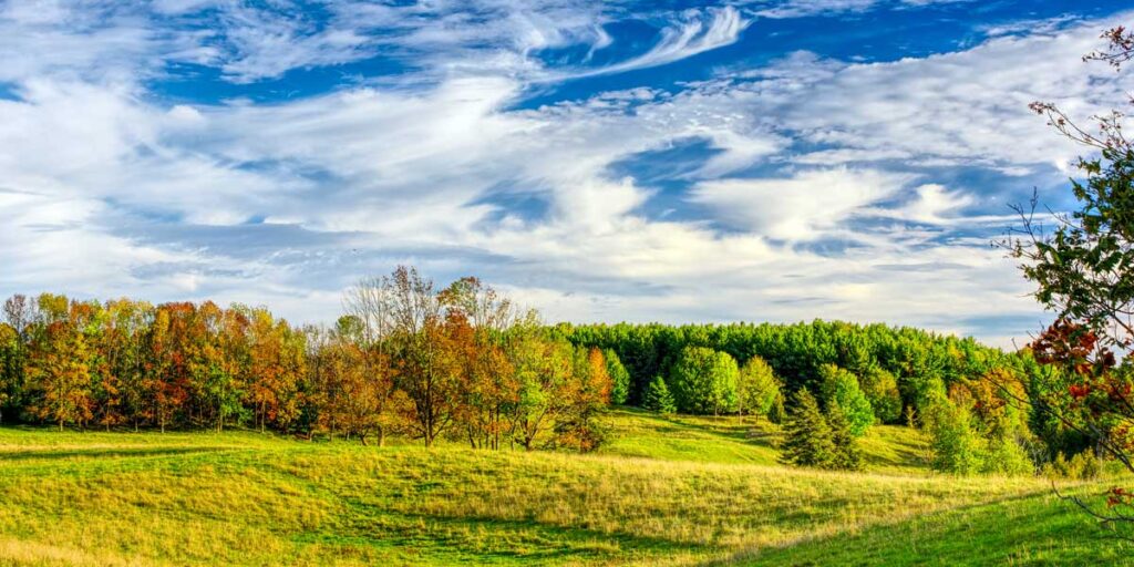 Panoramic view of pasture and forested hills in Wingham, Huron County, Ontario, Canada.