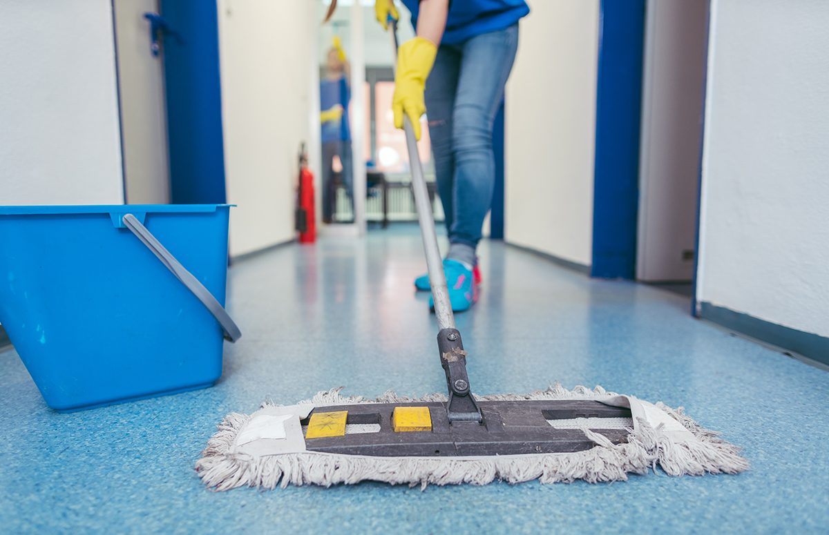 Close-up of cleaners moping the floor of a hall